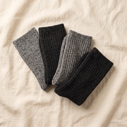 Boot Bundle flat lay - 4 pairs of alpaca boot socks folded on cream linen